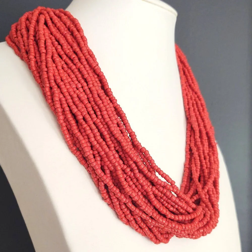 Layered orange beaded necklace with old coin toggle closure